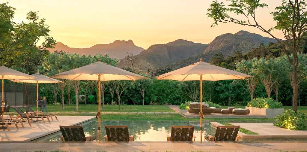 Piscina e área de descanso com vista para a serra